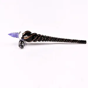 Detailed macro view of a black and blue spiral glass dip pen with a glass pen rest.