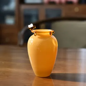 Handcrafted amber glass vase with decorative bee ornament for elegant home decor