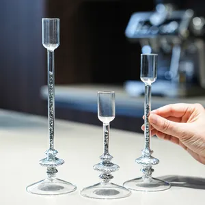 Set of three elegant glass candle holders with silver glitter flow in a lifestyle setting.