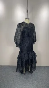 Close-up detail of the black flocked polka dot maxi dress with elegant puff sleeves.