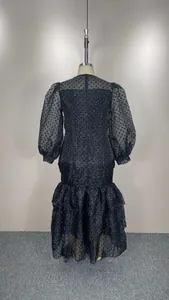 Back view of elegant black puff sleeve dress with flocked polka dots and tiered ruffles