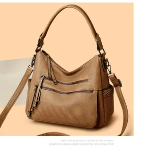 Brown leather hobo shoulder bag detail, multi-zipper pocket design for daily commute.