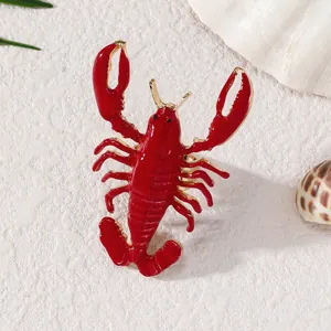 Primo piano di un anello di astice rosso vivo in lega con smalto, stile spiaggia marina.