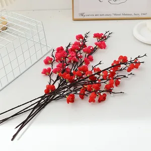 Detailed close-up shot of artificial red plum blossom branches for home decor and photo props.