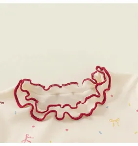 Dettaglio colletto t-shirt bambina, grazioso bordo volant rosso e stampa fiocco dolce.
