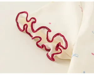 Grazioso dettaglio della manica della t-shirt da bambina con bordo arricciato rosso e pois.