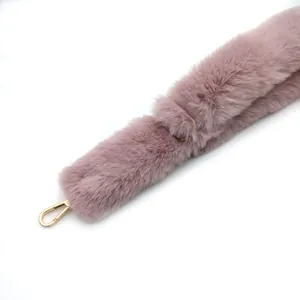 Detalle de correa de bolso de peluche, hombrera de pelo sintético con herrajes dorados.