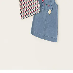 Ensemble deux pièces enfant avec t-shirt rayé et robe en denim avec de jolis petits détails.