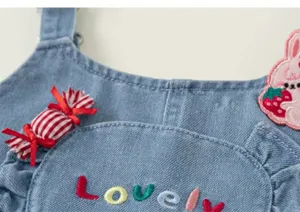 Vue détaillée d'une adorable salopette en jean pour fille avec broderie de bonbons et lapin.