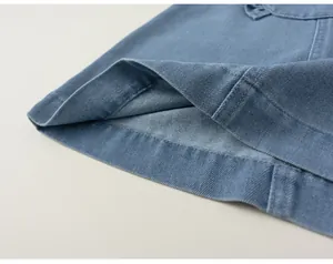 Photo de détail de vêtements en denim bleu pour enfants, coutures fines et tissu doux.