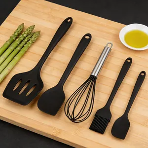 Vue détaillée du set d'ustensiles de cuisson en silicone avec spatule et fouet résistants.