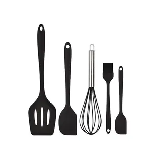 Détail de l'ensemble d'ustensiles de cuisine en silicone noir, spatules et fouet résistants.