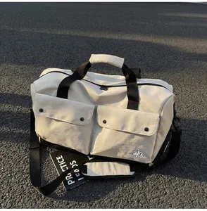 Detailansicht der großen Canvas Reisetasche mit Vordertaschen und robustem Schultergurt.