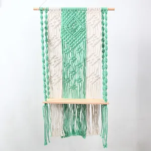 Boho macrame wall hanging shelf detail showing green and white woven cotton cord texture.