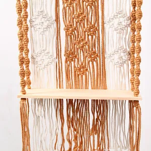 Handmade macrame wall hanging shelf detail showing boho woven cotton rope texture and wooden board.