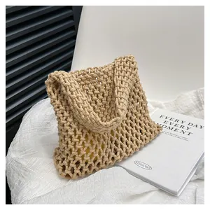 Nahaufnahme einer handgefertigten hohlen Baumwollseil Handtasche, beigefarbene Textur, Strand.