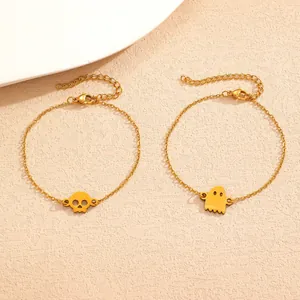 Detail view of gold Halloween bracelets featuring ghost and skull charms.