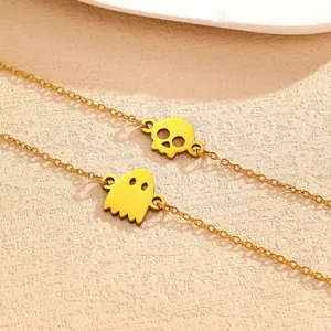 Close-up of gold-colored Halloween bracelets with skull and ghost metal pendants