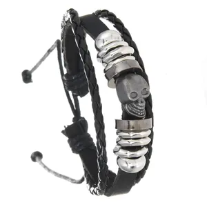 Close-up detail van een punk leren herenarmband met een zilveren schedelkraal