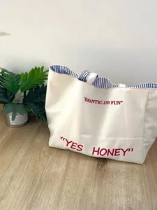 Large capacity canvas tote bag with striped lining and chic embroidered lettering design.