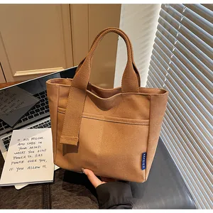 Borsa a mano in tela casual da donna, shopper minimalista con manici e tasca anteriore.