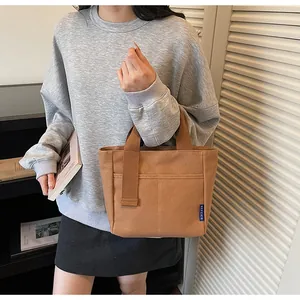 Borsa tote casual marrone in tela di dettaglio, con manici resistenti e tasca anteriore pratica.