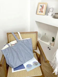 Detailed view of the blue and white striped canvas tote bag showcasing texture and embroidery.