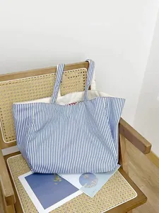 Detail shot of blue and white striped canvas tote bag showing texture and inner print.