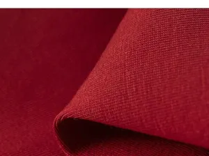 Gros plan détail tissu tricoté rouge montrant une texture douce pour vêtements d'enfants.