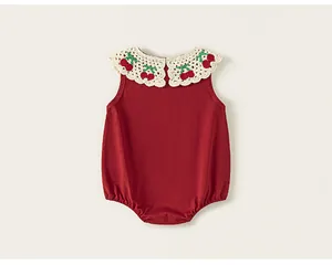 Détail de barboteuse sans manches pour bébé rouge avec col crochet et broderie cerise.