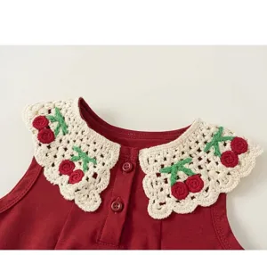 Robe sans manches rouge pour fille avec col crocheté blanc, broderie cerise et boutons.