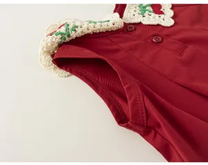 Vue de détail de robe sans manches rouge, avec col en dentelle crochet et jolis boutons.