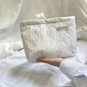 Detailed view of the quilted cosmetic bag featuring elegant tulip print and soft fabric texture.