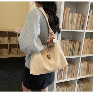 Vue détaillée d'un grand sac cabas beige en cuir souple avec un joli bijou de cheval