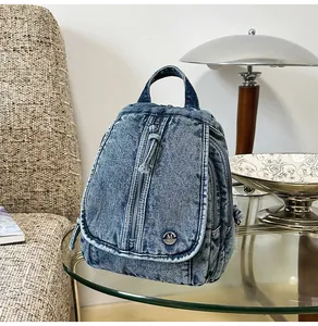 Detailansicht eines vintage gewaschenen blauen Denim-Rucksacks auf einem Glastisch