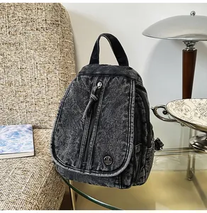 Nahaufnahme eines schwarzen Vintage-Denim-Rucksacks auf einem Glastisch in einem Zimmer