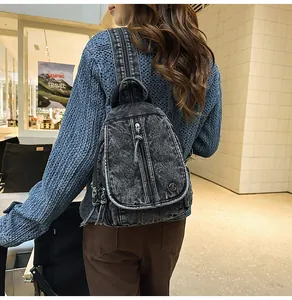Rückansicht einer Frau mit einem schwarzen gewaschenen Denim-Multifunktionsrucksack.
