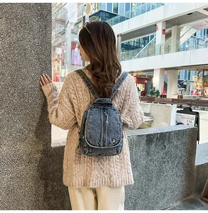 Rückansicht eines Models mit einem modischen Vintage-Mini-Rucksack aus gewaschenem Denim