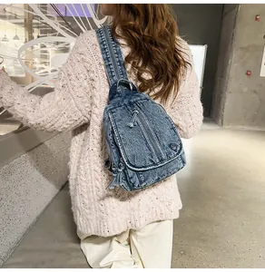 Detail einer Vintage-Denim-Umhängetasche, getragen von einem Model in Industrieumgebung