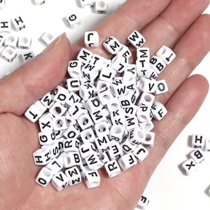 Détail de perles de lettres carrées en acrylique noir pour bracelets et bijoux DIY personnalisés.