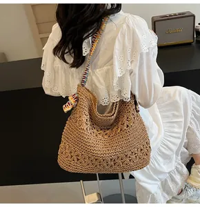 Detailansicht der großen, hohl gewebten Stroh-Tote-Tasche mit buntem Bohème-Riemen