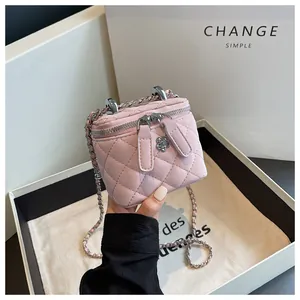 Close-up detail of a pink quilted vanity box bag with an elegant silver chain strap