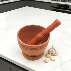 Gedetailleerd overzicht van handmatige keramische vijzel met stamper op aanrecht voor knoflook.