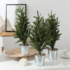 Mini albero di Natale finto in vaso di metallo con aghi di pino per decorazione.