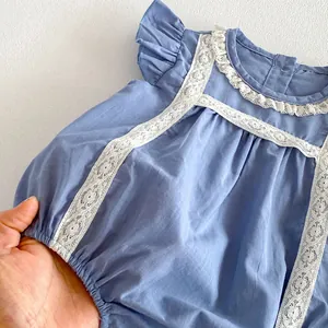 Nahaufnahme Detail des blauen Kleinkind-Bodys mit zarter weißer Spitzenborte und Flatterärmeln.