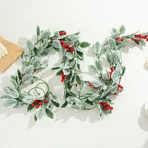Detailansicht der künstlichen Weihnachts-Stechpalmen-Beeren-Girlande mit gefrosteten Blättern.