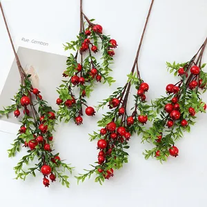 Vue détaillée de branches de baies rouges artificielles, idéales pour la déco de table.