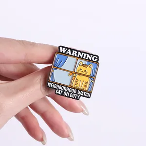 Close-up van een grappige oranje kat emaillen speld, gedetailleerd metalen badge.