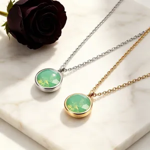 Primer plano detallado de collares con piedra verde facetada chapados en oro y plata.