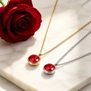 Primer plano de elegantes colgantes de piedras rojas en acero de titanio chapado en oro